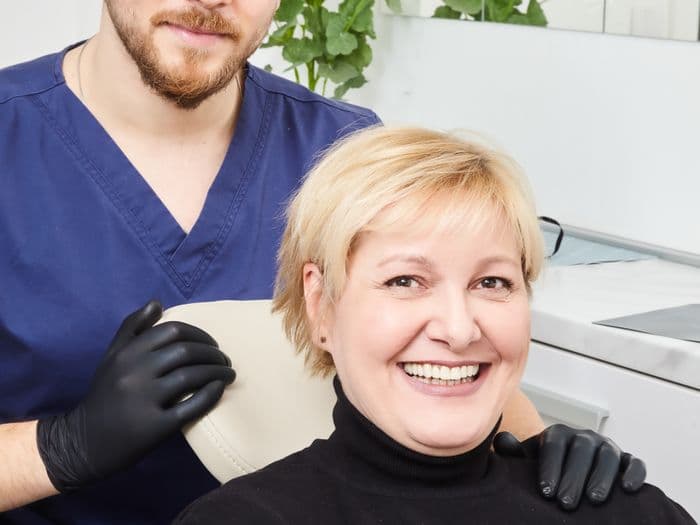 Patient celebrating successful implant result with her dentist